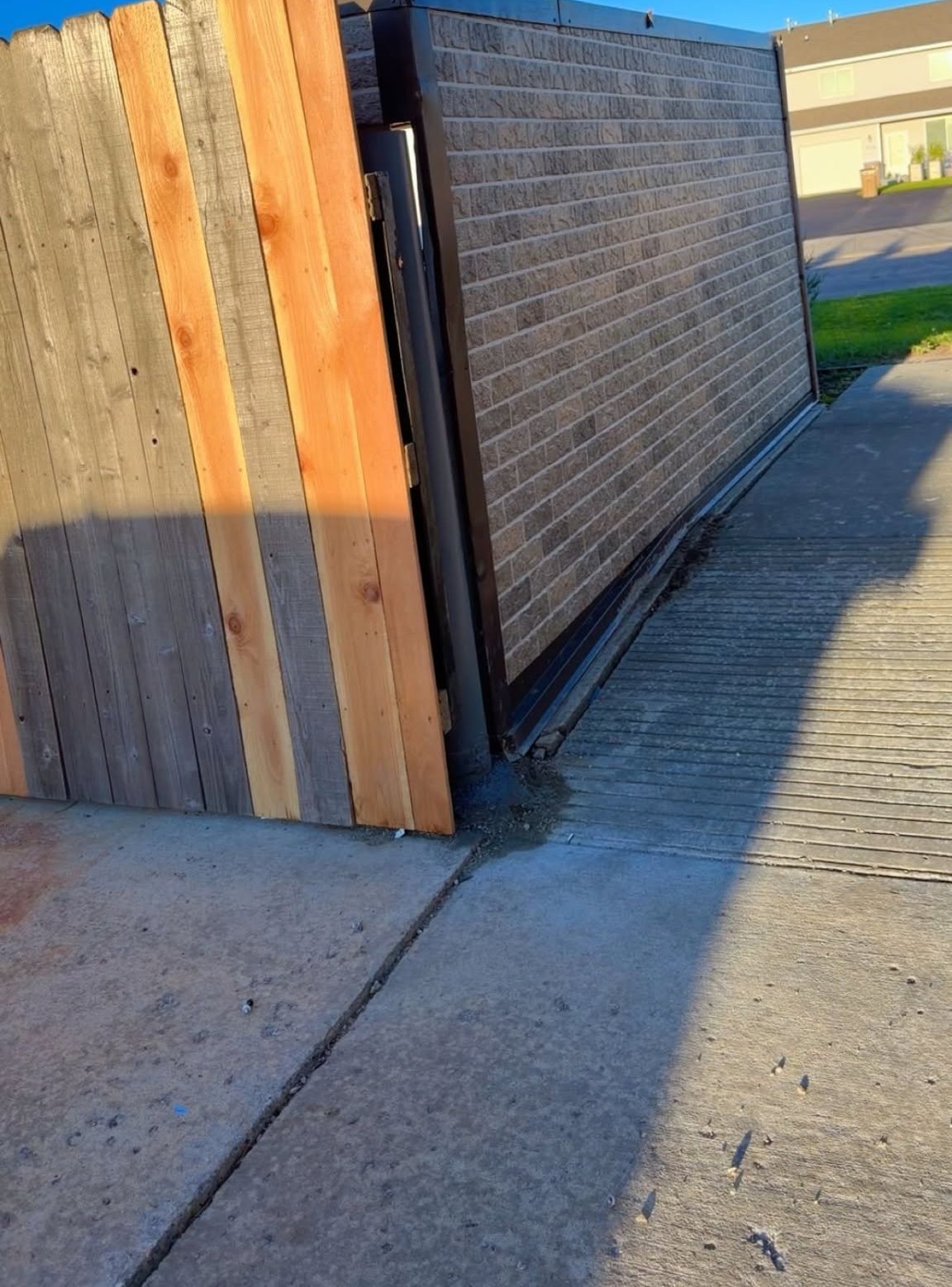 Repaired dumpster enclosure with new fence and post